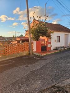 a house on the side of a road with a fence at Casinha de chocolate in Outeiro