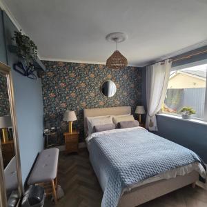 a bedroom with a bed and a blue wall at Salmon island view in Dromineer