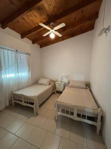 two beds in a room with a ceiling fan at Casa Marina in Monte Hermoso +23 photos