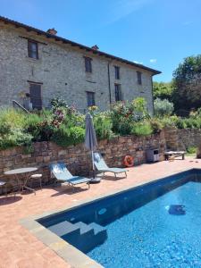a house with a swimming pool and two chairs and an umbrella at La Luna Buona in Vesime +50 photos