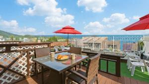 a table with a plate of food on a balcony at Geojedo Pilos Ocean View Pension in Geoje
