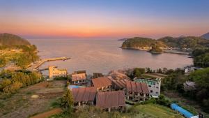 an aerial view of a resort on the water at sunset at Geojedo Pilos Ocean View Pension in Geoje