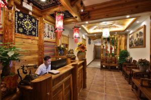 a man sitting at a bar in a restaurant at Chong Chong Guesthouse in Zhangjiajie