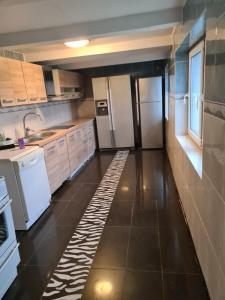 a kitchen with white appliances and a tile floor at Blu hus in Norra Kverrestad