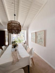 a dining room with a white table and white chairs at Casa Marina in Monte Hermoso