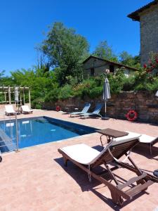a swimming pool with two lounge chairs next to at La Luna Buona in Vesime