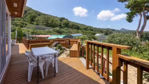 a wooden deck with a table and chairs on it at Ganghwa Herb Pension in Incheon