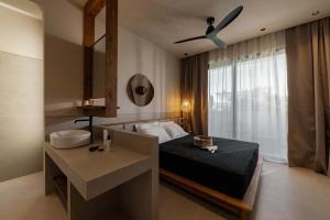 a bedroom with a bed and a sink and a ceiling fan at Terra Mare Villas in Ialysos