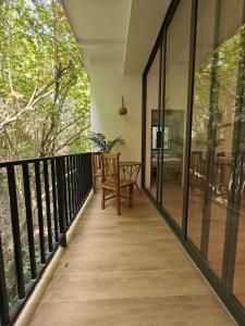 a balcony with glass doors and a wooden table at Ganesha Mouse House in Ko Phangan