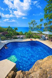 a swimming pool with a view of the ocean at Ganesha Mouse House in Ko Phangan