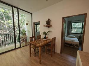 a dining room with a table and a balcony at Ganesha Mouse House in Ko Phangan