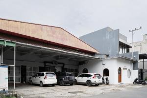 two cars parked in a parking lot in front of a building at Urbanview Hotel Cozy Samarinda by RedDoorz in Samarinda +18 photos