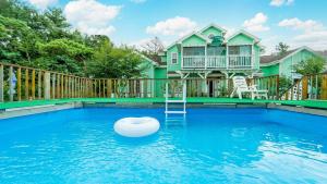 a house with a swimming pool in front of a house at Youngheungdo Roma Spa Pension in Incheon