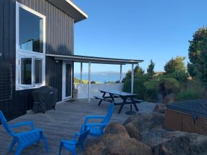 a patio with blue chairs and a picnic table at Wharau Lodge in Kerikeri +8 photos