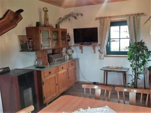 a living room with a kitchen with a tv on the wall at Götschlhütte in Bad Sankt Leonhard im Lavanttal