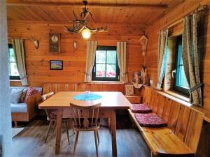 a dining room with a table and chairs in a log cabin at Götschlhütte in Bad Sankt Leonhard im Lavanttal