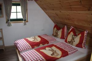 two beds with red and white covers in a room at Götschlhütte in Bad Sankt Leonhard im Lavanttal +6 photos