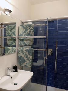 a bathroom with a sink and a shower with blue tiles at B&B Il Campanile in Barletta