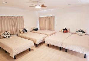 three beds in a room with white walls and a ceiling at Itoshima STAY YAMAGA Keya in Itoshima