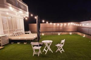 a patio with a table and chairs on the grass at Itoshima STAY YAMAGA Keya in Itoshima