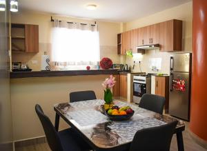 a kitchen with a table with a bowl of fruit on it at Zinari Comfort Homes in Nakuru