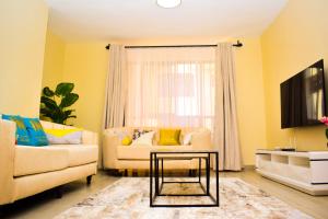 a living room with a couch and a table at Zinari Comfort Homes in Nakuru
