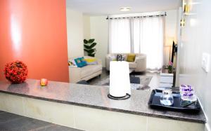 a kitchen with a counter top and a living room at Zinari Comfort Homes in Nakuru +5 photos