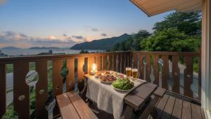 a table with a plate of food on a balcony at Geoje Gaonara Pension in Geoje