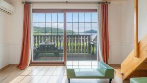 a living room with a large window with a view at Geoje Gaonara Pension in Geoje +1 photo