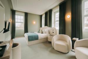 a bedroom with a king sized bed and a chair at Torel Private Collection in Porto