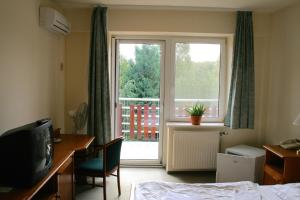 een hotelkamer met een bed en een groot raam bij Well Hotel in Harkány
