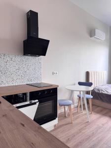 a kitchen with a stove and a table and a bed at comfortable apartment in Vancouver