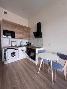a kitchen with a table and a sink and a washing machine at comfortable apartment in Vancouver