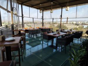 a restaurant with tables and chairs and large windows at Myspace Chindanur Comforts in Chitradurga