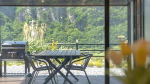a picnic table and two chairs on a deck with a view at Danyang Dandelion Pool Villa in Danyang