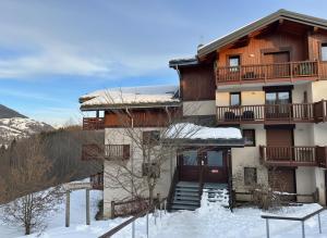 a large building with snow on the ground at L'Ecrin des Myrtilles - Appartement cosy - Piscine et vue montagne - Alpes - Val d'Arly - Aravis et Beaufortain in Flumet