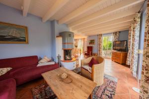 a living room with a red couch and a fireplace at Ferienhaus Möwe in Krienke