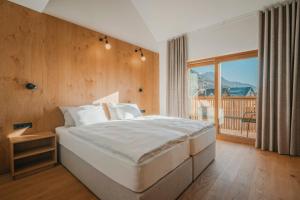 a bedroom with a large bed and a balcony at Trivrh Outdoor Hotel in Žirovnica