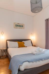 a bedroom with a large bed with two towels on it at Villa 2 Quartos by WOT Lodge Soul in Ericeira