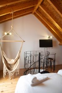 a hammock in a bedroom with a bed and a tv at Villa 2 Quartos by WOT Lodge Soul in Ericeira