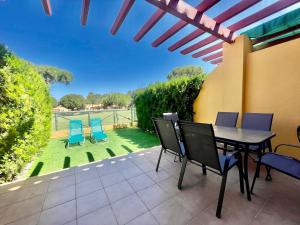 a patio with a table and chairs and a lawn at Albatros Golf 2 - Islantilla in Isla Cristina