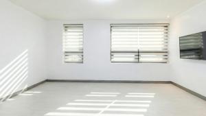a room with white walls and windows with shadows on the floor at Yeosu Onueli Pension in Yeosu +10 photos