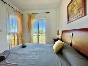 a bedroom with a bed and a large window at Albatros Golf 2 - Islantilla in Isla Cristina +10 photos