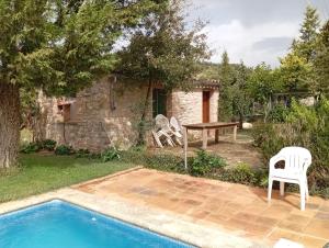 Eine Terrasse mit Tisch und Stühlen neben einem Pool in der Unterkunft Moixons in Calonge de Segarra