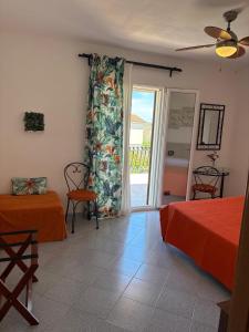 a bedroom with two beds and a sliding glass door at Sunrise in Lascari