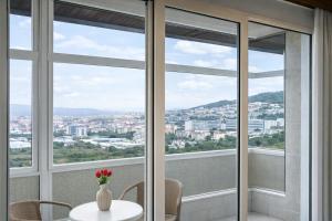a room with a table with a vase of flowers at Hotel San Rosendo in Ourense