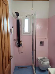 a bathroom with a toilet and a glass shower at Siroco's Rooms And Studios in Parikia +44 photos
