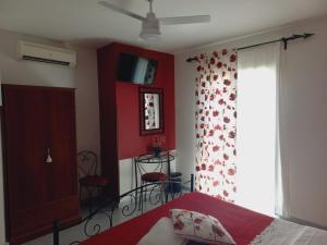 a bedroom with a bed with a red wall at Sunrise in Lascari