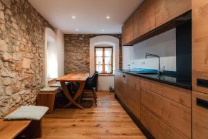 a kitchen with a wooden table and a dining room at Vila Podigrac in Zgornja Kungota