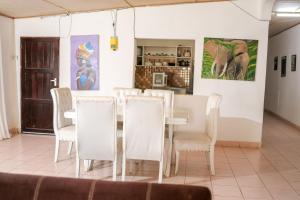 a dining room with a table and white chairs at Cosy Garner Haven Watamu in Watamu